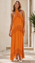 Model wearing bright orange halter neck tiered fringe maxi dress from the front