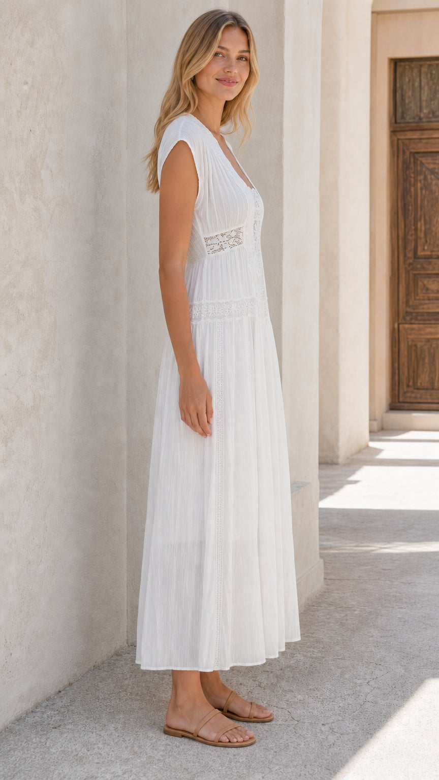 Side profile of woman wearing white lace panel maxi dress