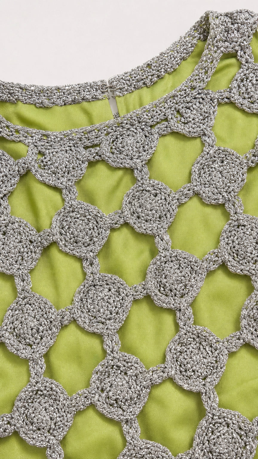 Close-up detail of silver metallic circular crochet pattern and lime green lining