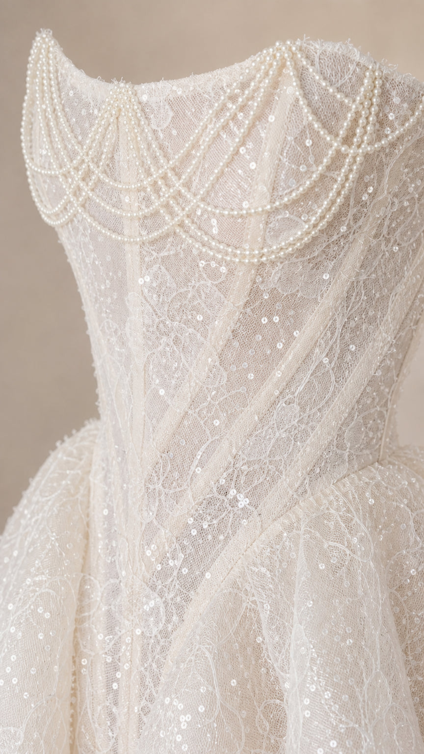 Close up of bodice with pearl draping and lace detail on white dress