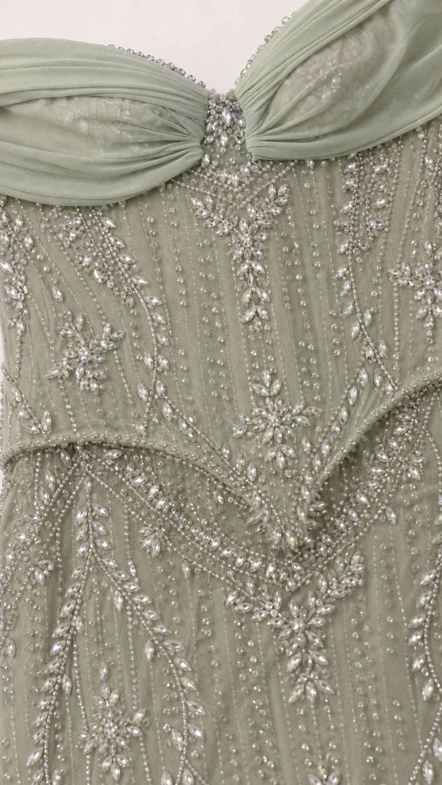Close-up detail of beaded bodice and draped neckline in sage green