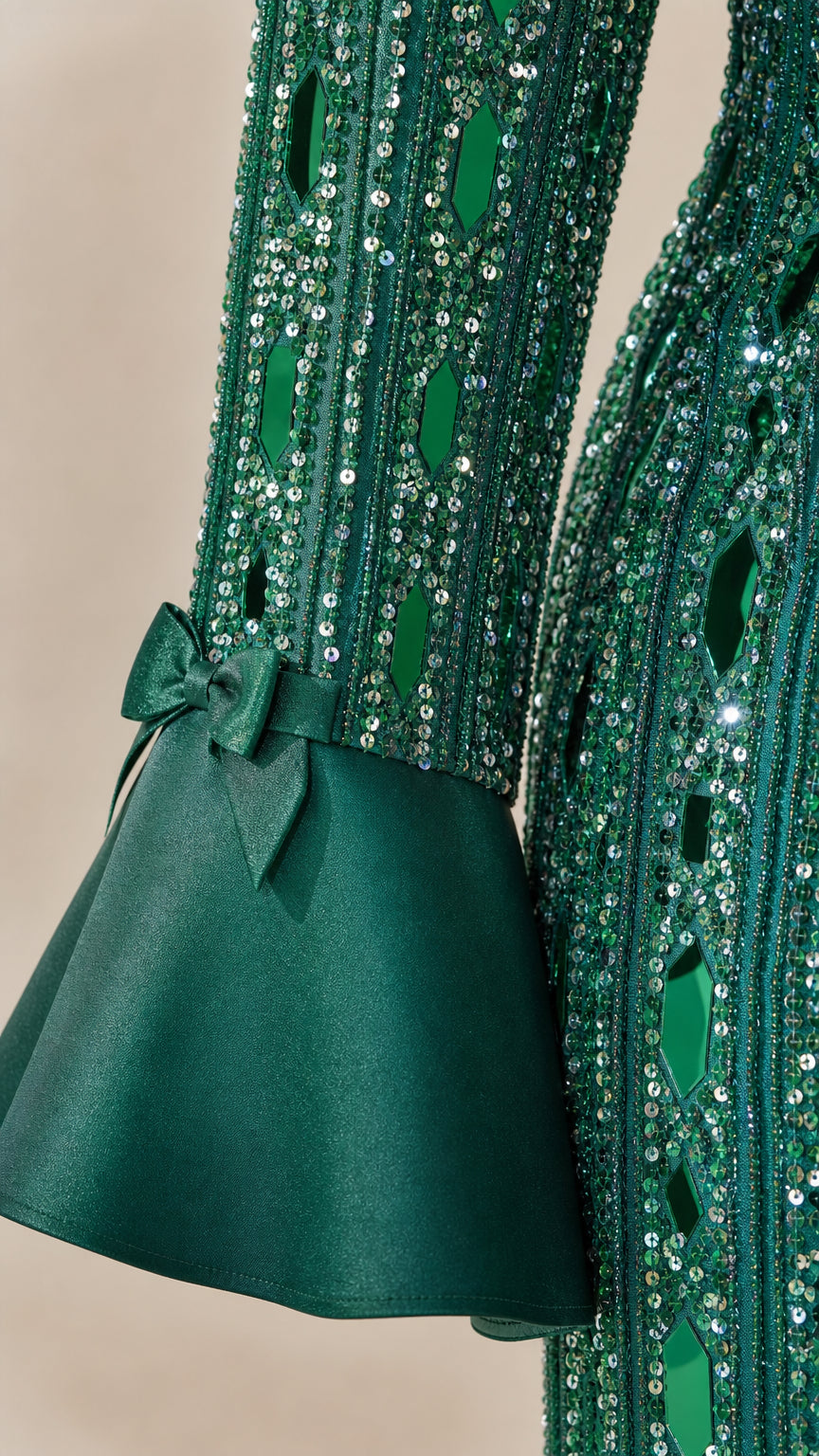 Close-up of sequin texture and bow cuff detail on green sleeve
