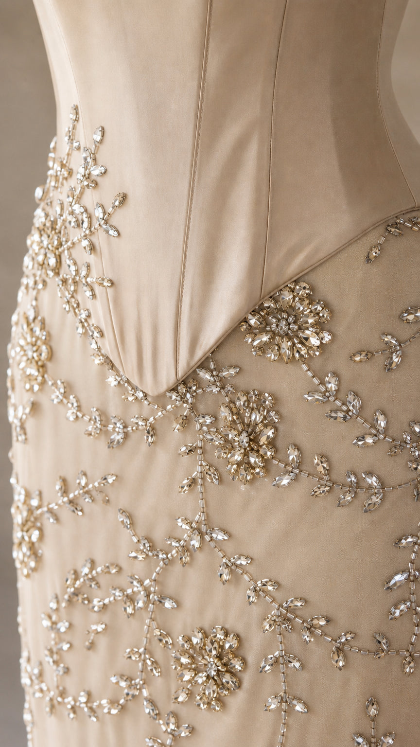 Close-up detail of rhinestone and bead embroidery on champagne dress