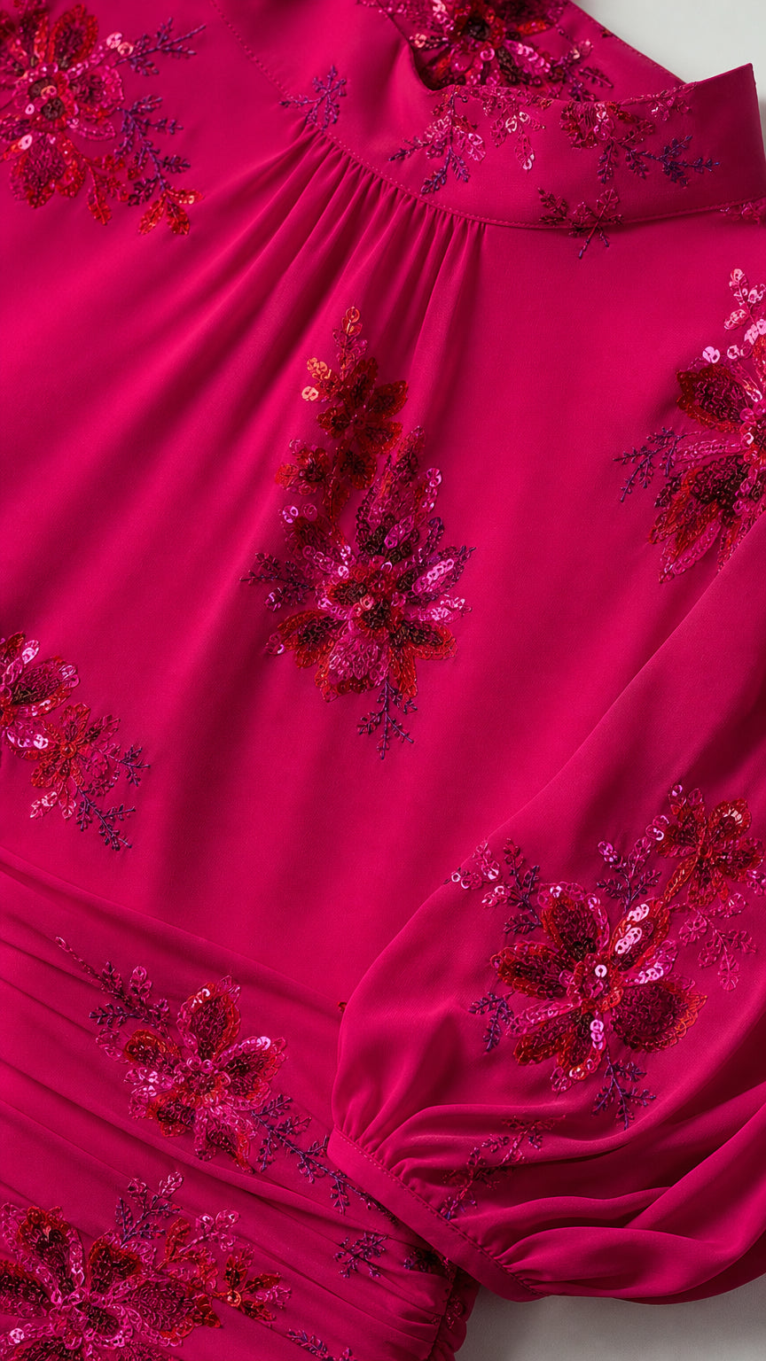 Close-up detail of sequin floral embroidery on Fuchsia dress fabric
