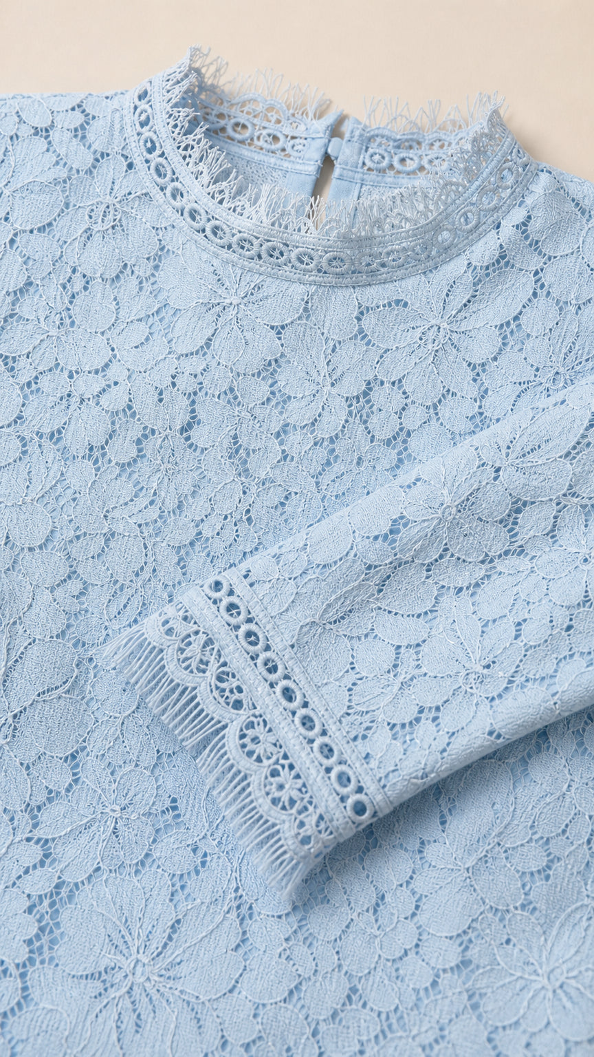 Close-up detail of lace pattern, mock neck, and cuffs