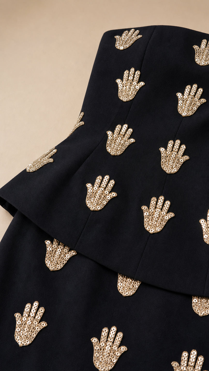 Close-up detail of sequin hand embellishments and peplum waist