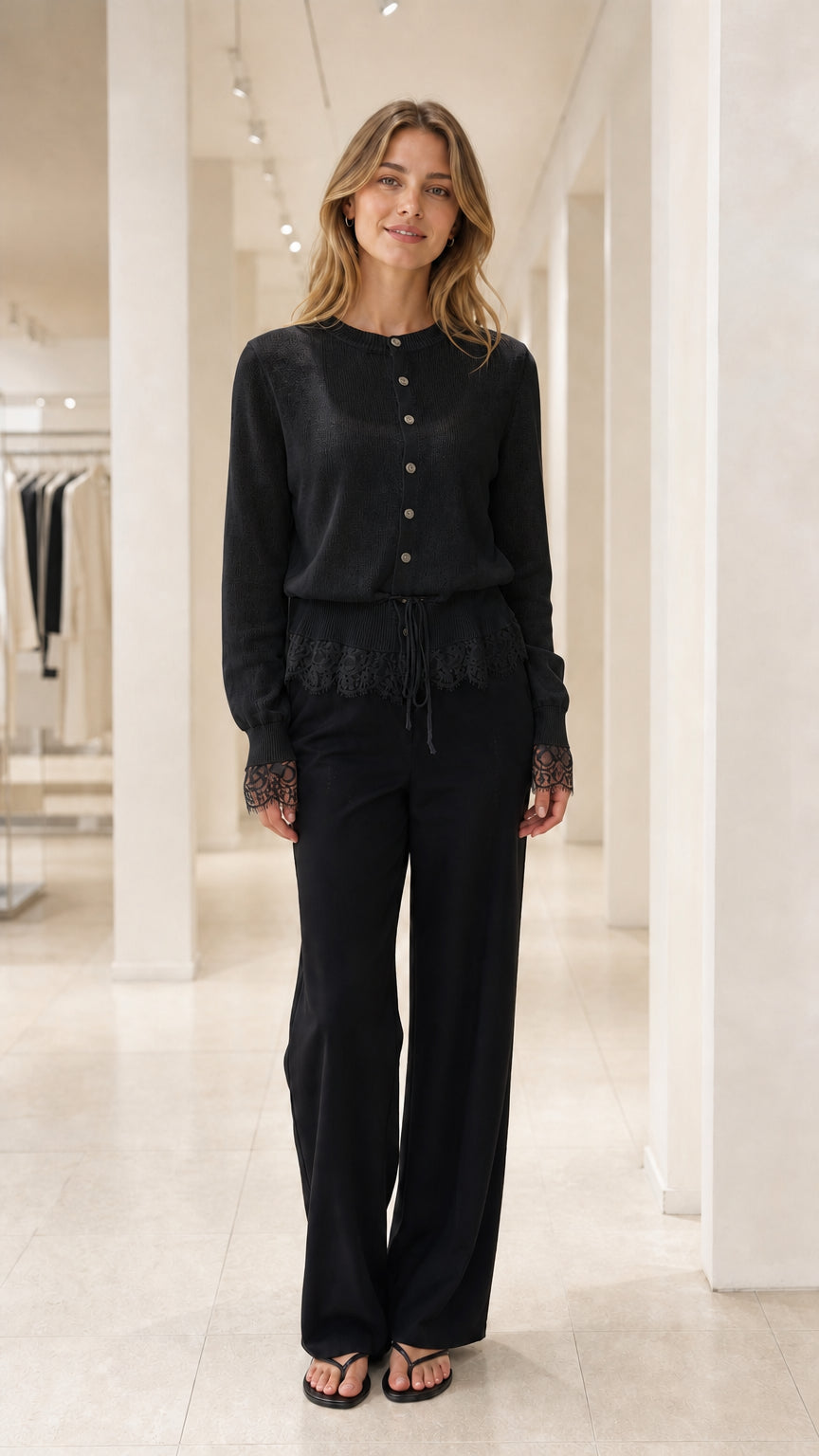 Front view of Black lace-trimmed knit cardigan and black trousers