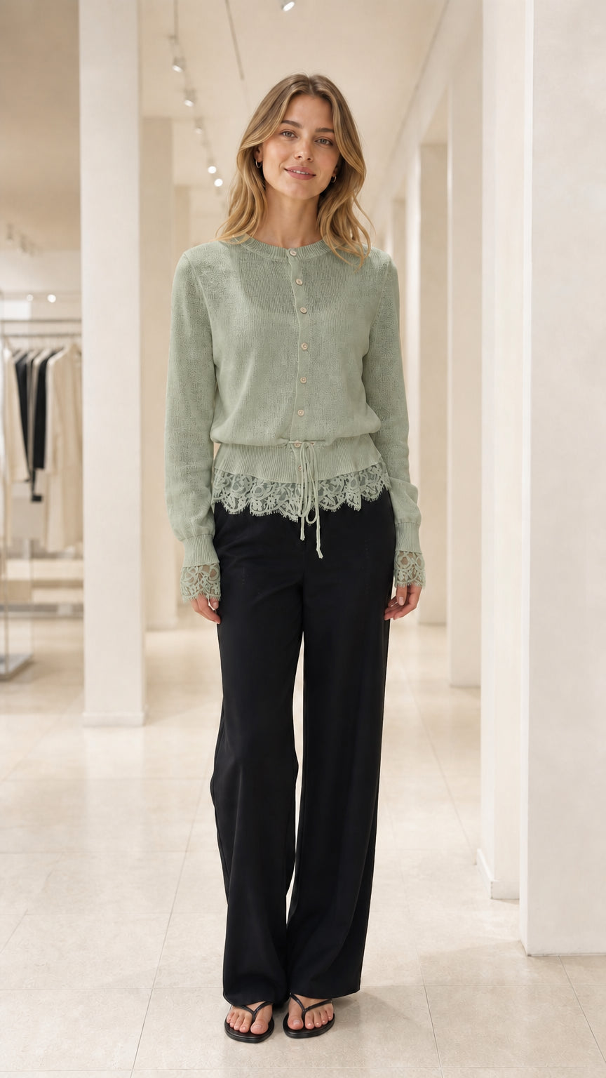Front view of Sage Green lace-trimmed knit cardigan and black trousers