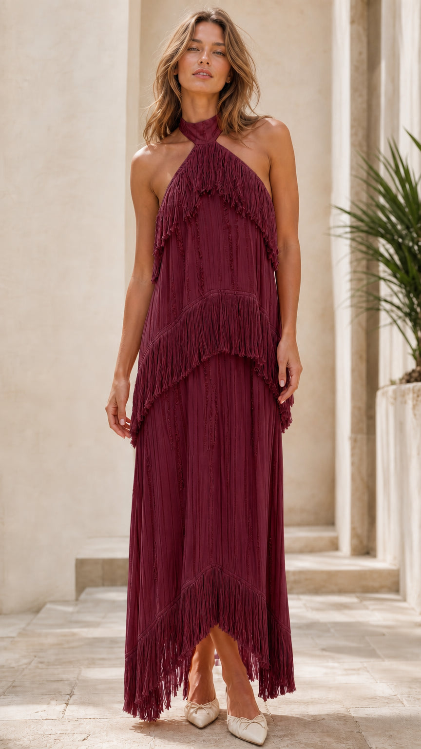 Model wearing burgundy halter neck tiered fringe maxi dress