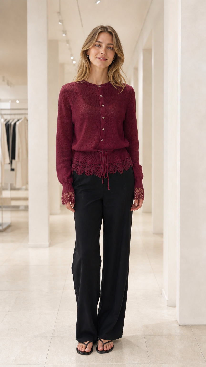 Front view of Burgundy lace-trimmed knit cardigan and black trousers